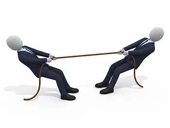 スーツ姿の二人のビジネスマンが一本の綱を互いに引き合っている綱引きの様子