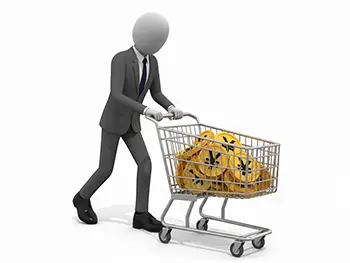 日本円のマークが入ったコインが山積みになったショッピングカートを押すスーツ姿のビジネスマン