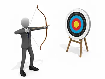 弓と矢を構えて、前方の的の中心を真剣に狙っているスーツ姿のビジネスマン