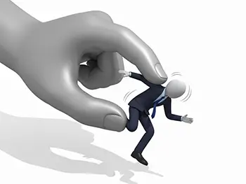 逃げようとしているスーツ姿の小さなビジネスマンを、巨大な手が上からつまんで捕まえようとしている