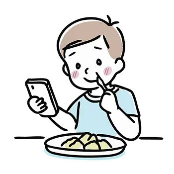食事をしながらスマートフォンを笑顔で見る男の子の無料イラスト