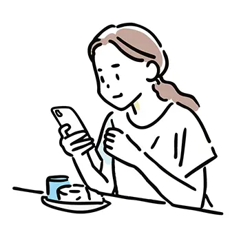 カフェでケーキを食べながらスマートフォンを見る女性の無料イラスト