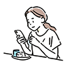 カフェでケーキを食べながらスマートフォンを見る女性の無料イラスト