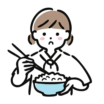 お茶碗のご飯を箸で持ち上げ、悲しそうな（困った）顔をする女の子の無料イラスト。