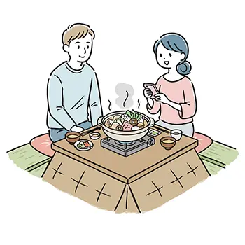 冬にこたつに入り、鍋料理を囲むカップル(女性がスマホで撮影)の無料イラスト