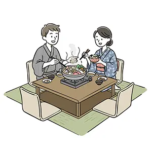 こたつに入って鍋料理を仲良く食べている和服姿の夫婦