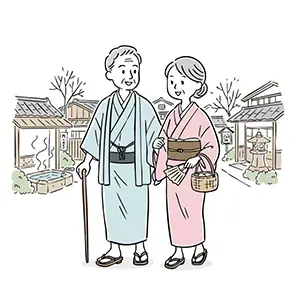 温泉街の通りを浴衣姿で散策している笑顔の高齢夫婦